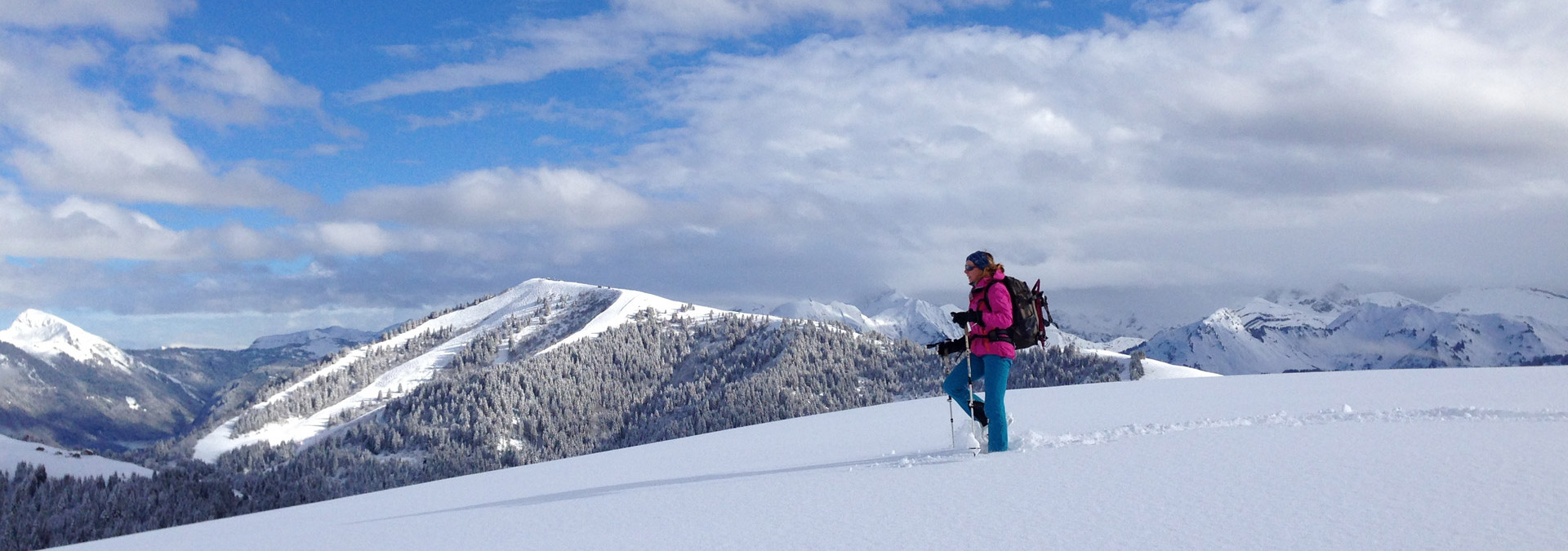 Snowshoe summits in Samo&euml;ns - Making fresh tracks in the snow with the Samo&euml;ns ski resort in the background.